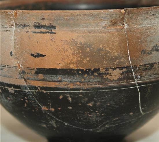 A Greek black slip decorated skyphos, Apulia, c.4th century BC, 22.5cm, broken and re-assembled